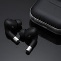 Close-up of black wireless earbuds showing ergonomic in-ear design